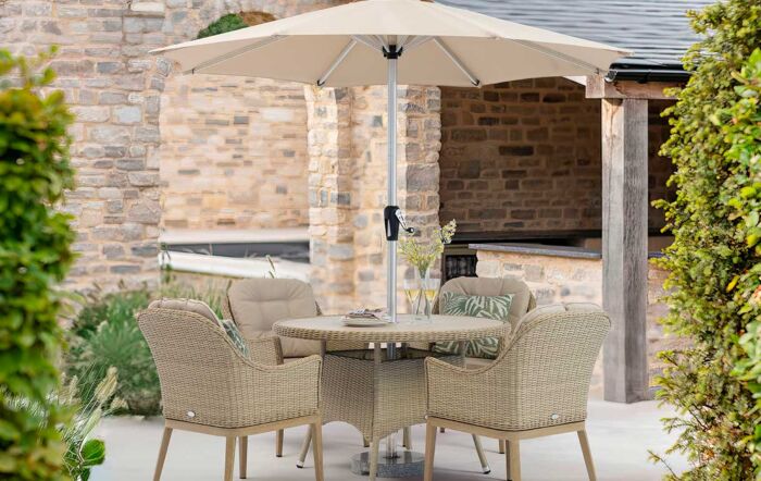 Bramblecrest Monterey Sandstone 120cm Round Dining Table & 4 Deluxe Vogue Armchairs, Parasol & Base 